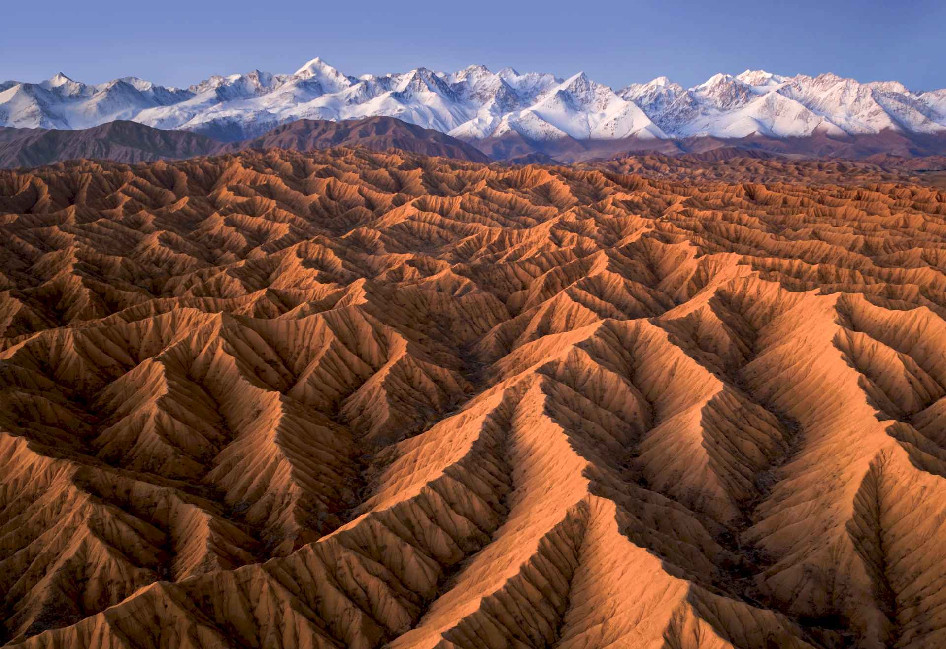 Snow-covered mountains over golden valleys in Kyrgyzstan