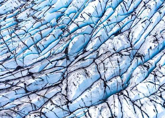Aerial view of a glacier's blue and white ice formations, Iceland