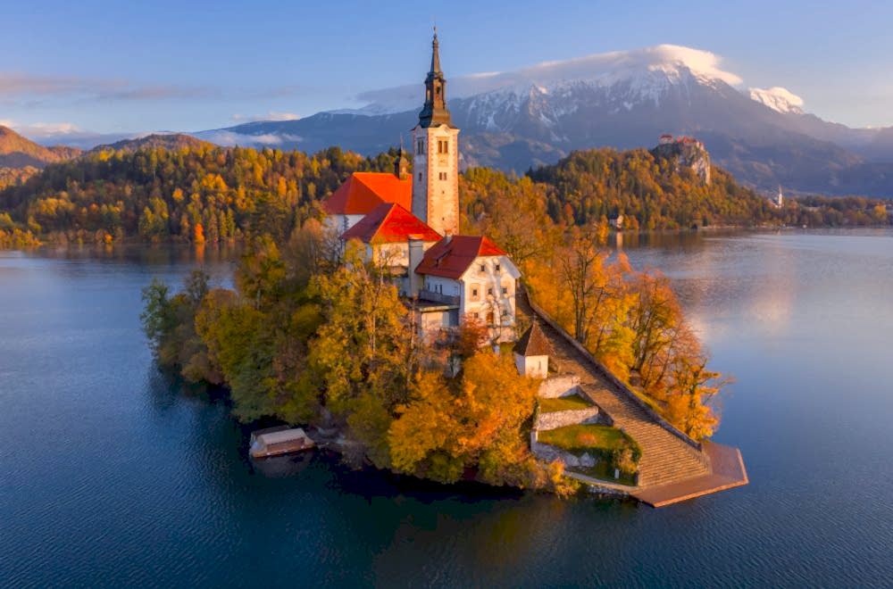 Church on island in Lake Bled, Slovenia, surrounded by autumn foliage