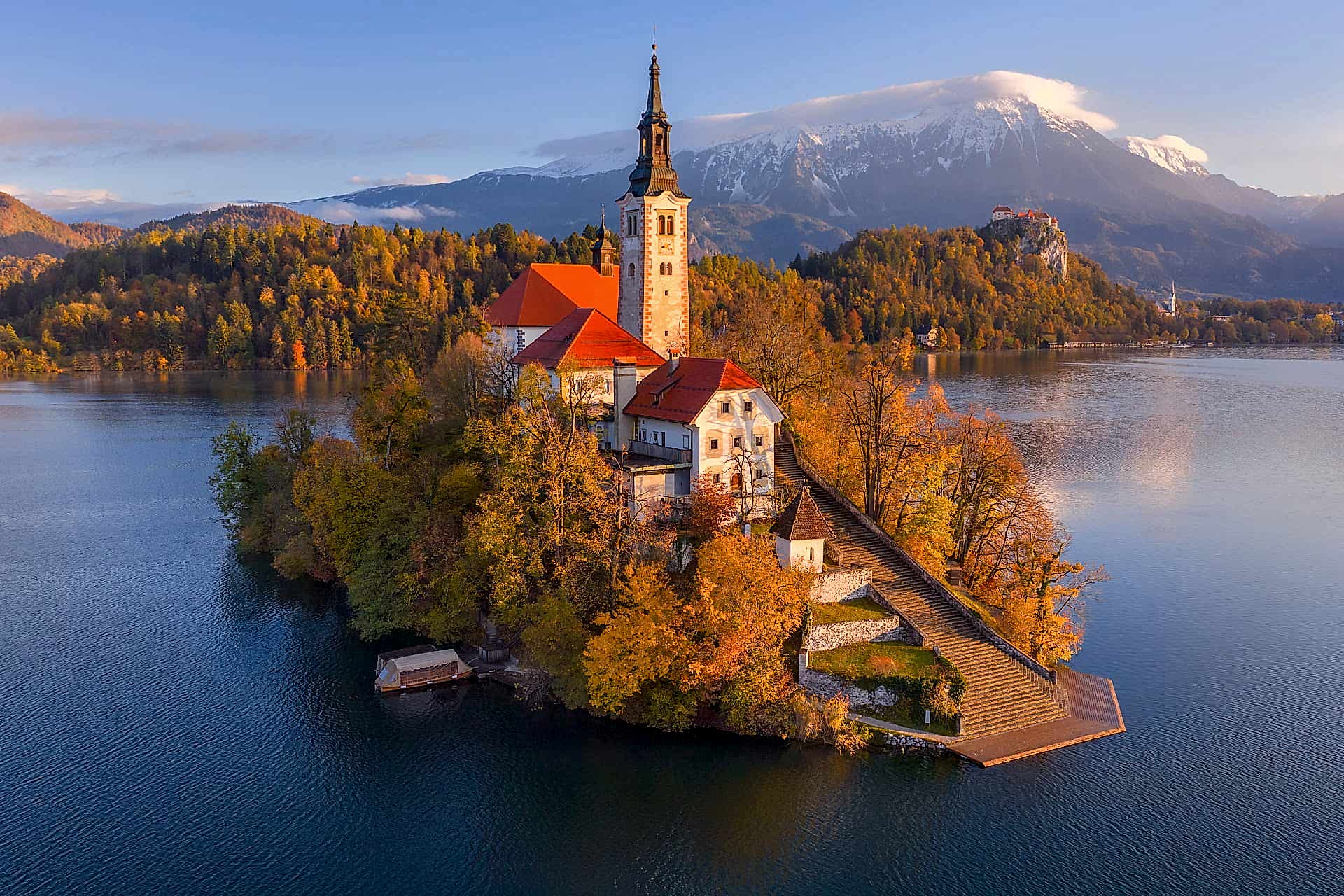Church on island in Lake Bled, Slovenia, surrounded by autumn foliage