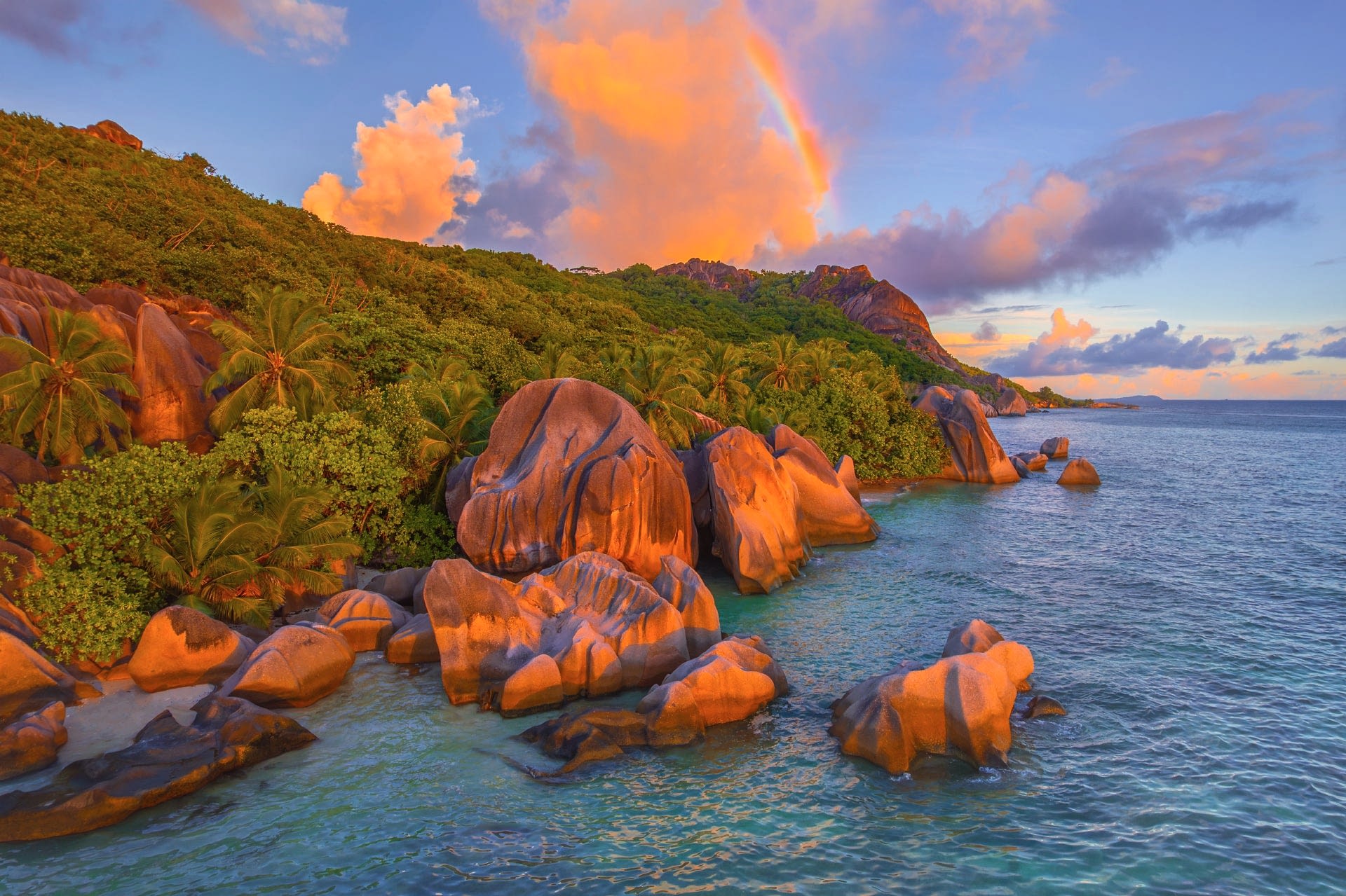 Rainbow arching over rocky coastline at La Digue, Seychelles